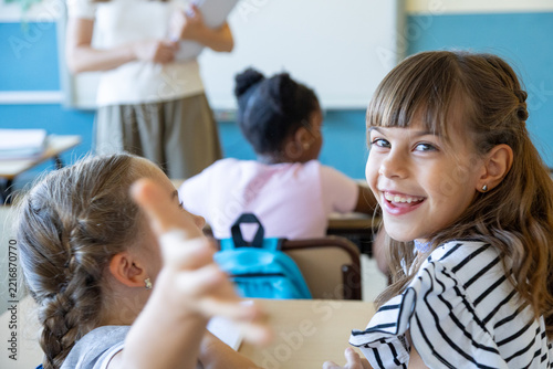 Happy primary schoolgirl smiling in classroom