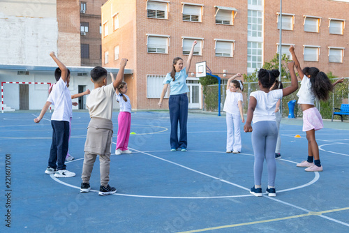 Children doing physical education exercises with teacher at school
