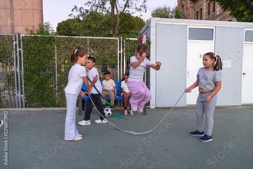 Children playing jump rope in school playground