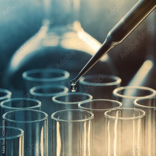 Droplet falling from pipette into laboratory test tubes