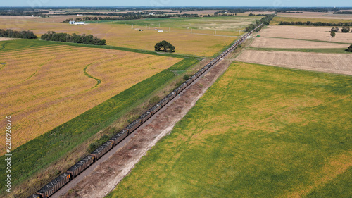 Freight train traveling through Midwestern farmland, aerial view