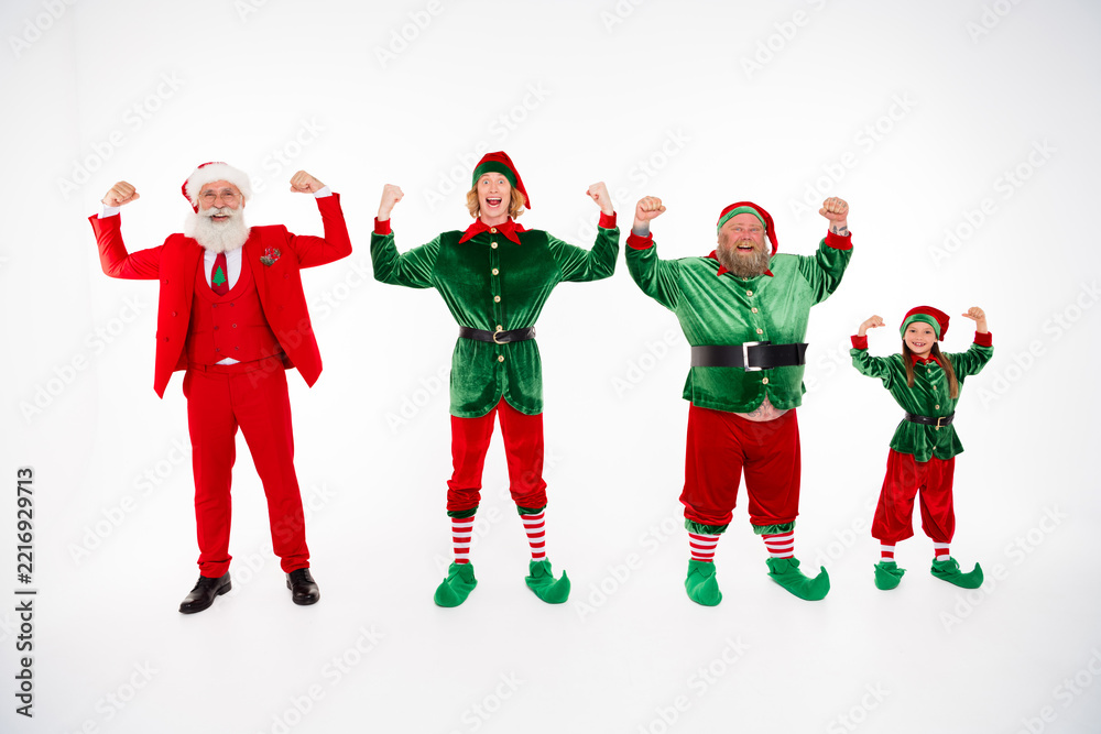 Fototapeta premium Santa and three joyful elves flexing together for a festive family Christmas celebration in holiday costumes