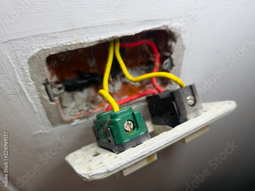 Electrical switch box disassembled on wall showing internal wiring connections