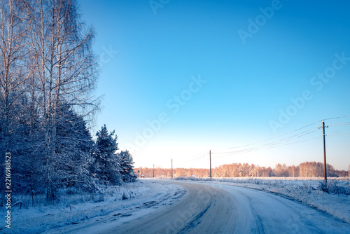 A winter road through the forest on a sunny, frosty day.