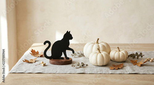 Black cat Halloween concept with Refined black cat silhouette ornament beside white pumpkins on a premium seasonal surface, fun autumn display, in a polished commercial composition
