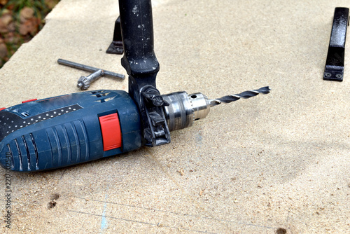 A professional-grade impact drill with a drill bit attached lies on the table.