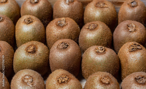fresh kiwi fruits neatly arranged in a wooden box. Whole organic raw kiwi pattern background, seamless eco friendly food market concept