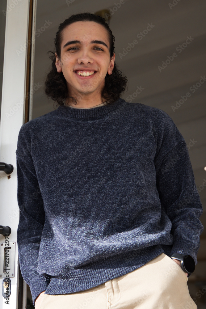 Fototapeta premium African American man standing smiling and leaning in home doorway with door lock and wristwatch