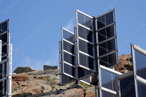 Detail of solar panels in mountains vertically mounted as four wings around central column like tree, photovoltaic plant avoid snow accumulation, future innovation energy concept