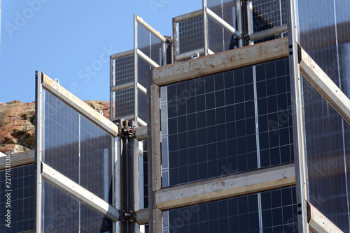 Detail of solar panels in mountains vertically mounted as four wings around central column like tree, photovoltaic plant avoid snow accumulation, future innovation energy concept