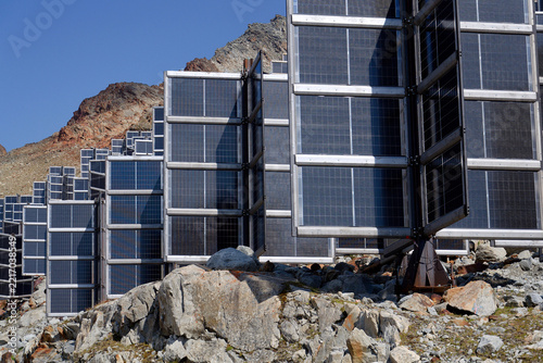 Detail of solar panels in mountains vertically mounted as four wings around central column like tree, photovoltaic plant avoid snow accumulation, future innovation energy concept