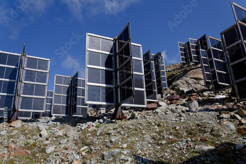 Detail of solar panels in mountains vertically mounted as four wings around central column like tree, photovoltaic plant avoid snow accumulation, future innovation energy concept