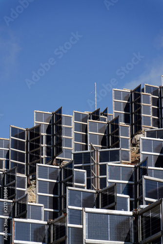 Detail of solar panels in mountains vertically mounted as four wings around central column like tree, photovoltaic plant avoid snow accumulation, future innovation energy concept
