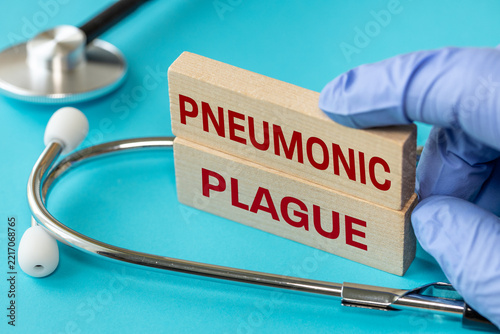Pneumonic plague text on wooden blocks with stethoscope. Dangerous infectious disease, healthcare and epidemiology concept.