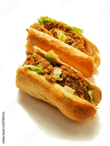 Crispy fried chicken filling in a soft, golden-brown roll bun. Fresh lettuce peeking through the savory meat. Clean white background highlights food texture and color. Perfect for fast food