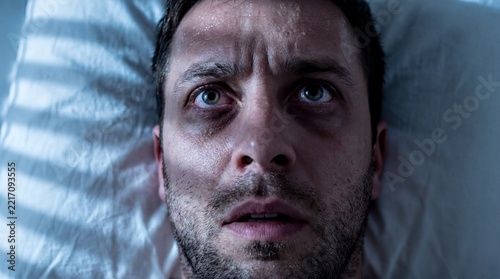 Severe Insomnia, A weary man lies awake in bed during the dead of night
