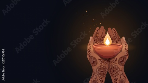 Hands adorned with intricate henna holding a glowing diya during Diwali festival