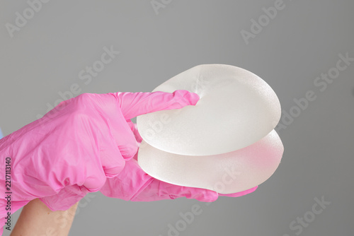 Breast Implants Held in Surgical Glove for Plastic Surgery Consultation