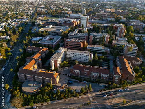 Aerial view of the University of Southern California campus featuring brick buildings, lush trees, and surrounding city streets in Los Angeles, California, United States.