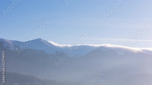 Aerial view over mountains in winter with mist and clear skies