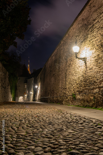 Narrow cobble stone street at night in Old Town Tallinn Estonia