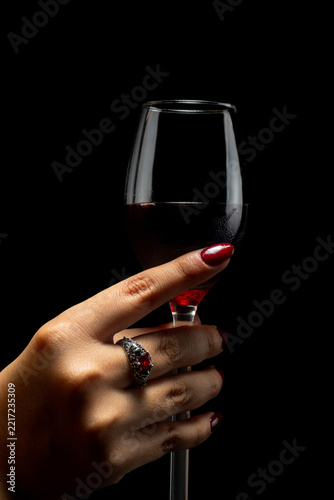 Elegant Female Hands with Burgundy Nail Polish and Vintage Ring on Black Background