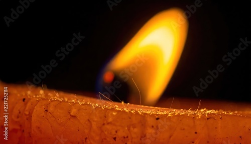 Close up of a burning candle flame in the dark.
