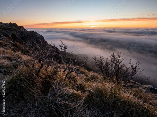 Winter morning frost on a mountain hillside overlooking a sea of clouds with mountain landscape atmosphere peaceful