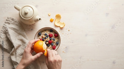 Overhead View of Hands with Breakfast Bowl Oranges and Tea