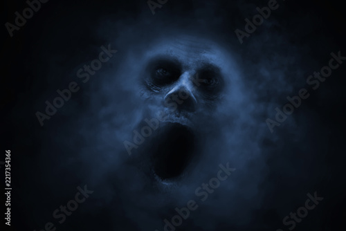 Screaming ghost face on black background with smoke mist fog, Halloween theme