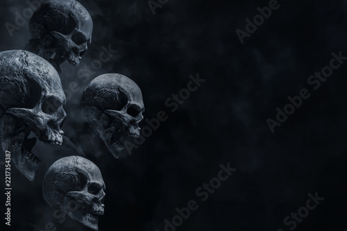 Group of human skull on dark background with smoke mist fog