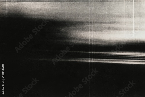 Abstract black and white image with horizontal streaks and a textured pattern, creating a moody, mysterious visual effect.