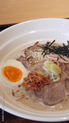 Bowl of Tonkotsu Ramen with Soft-Boiled Egg, Pork, and Nori on Wooden Table, Japanese Cuisine