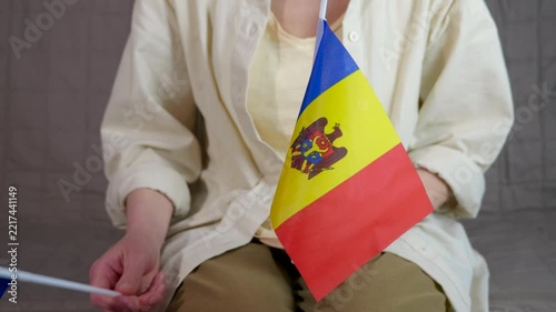 Person holding moldova and european union flags. Person holding small flags of moldova and the european union, symbolizing the country's aspiration to join the eu and partnership