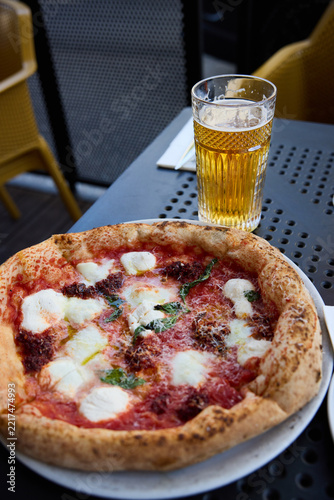 Delicious Neapolitan Pizza and Cold Beer on a Sunny Outdoor Terrace Table
