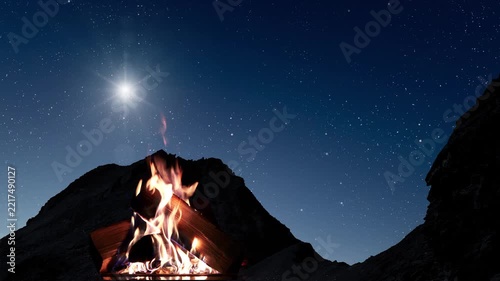 A campfire flickers beneath a brilliant star and a starry sky above dark mountains, evoking Christmas Eve.