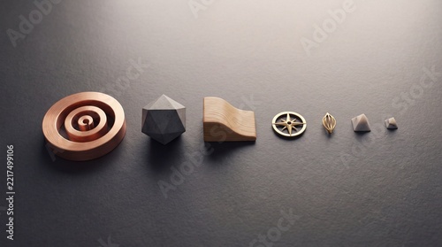 Minimalist collection of geometric objects featuring metal rings, a faceted polyhedron, wooden curve, and marble pyramids arranged in a row on a dark textured background for creative design.