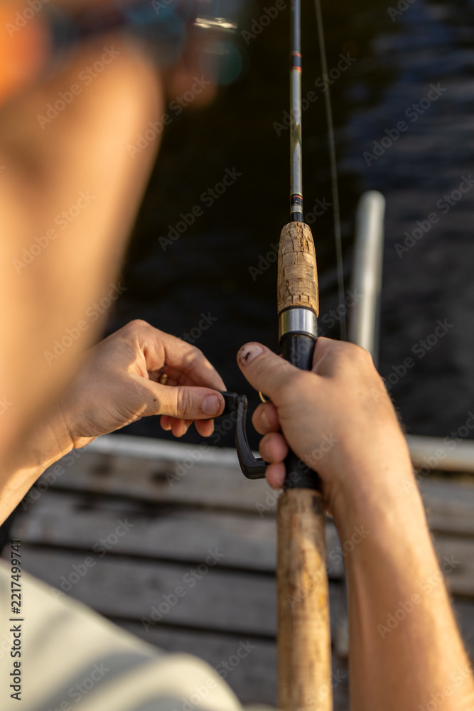 Fototapeta premium Close up of a person reeling in a fishing line