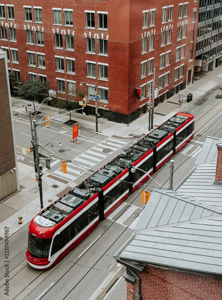 Fototapeta premium High angle view of a red streetcar on city streets of Toronto
