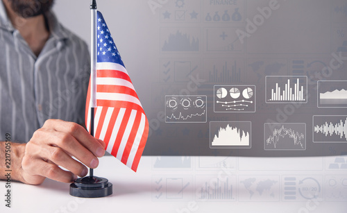 Man showing Us flag with a financial graphs.
