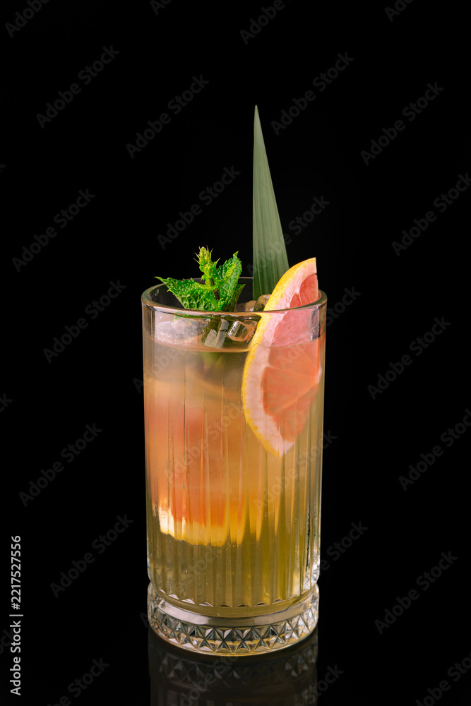 Fototapeta premium Refreshing grapefruit cocktail with mint and ice on black background