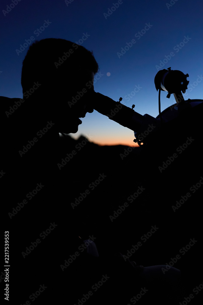 Fototapeta premium Amateur astronomer observing stars, planets, Moon and other celestial objects with a telescope in nature.
