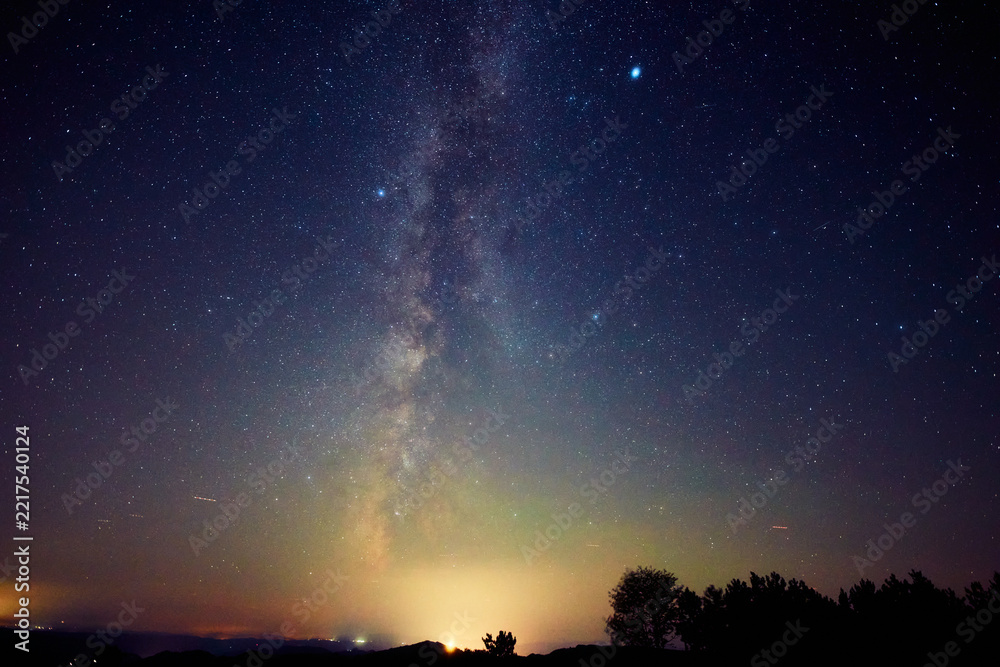 Fototapeta premium Summer Milky Way stars and landscape scenery silhouettes.
