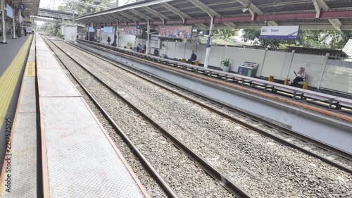 Empty train platform, some people waiting in the background
