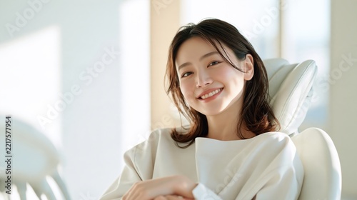 Happy young asian woman smiling confidently sitting in a dental chair