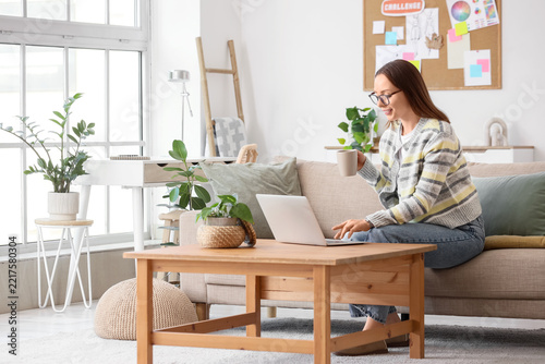 Remote work and digital nomad lifestyle, woman working on a laptop with coffe...