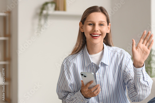 Video call and remote communication, happy woman waving hello during online m...