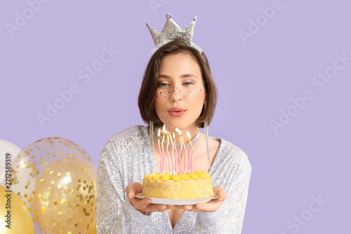 Birthday celebration and self care, young woman wearing a crown blowing out c...
