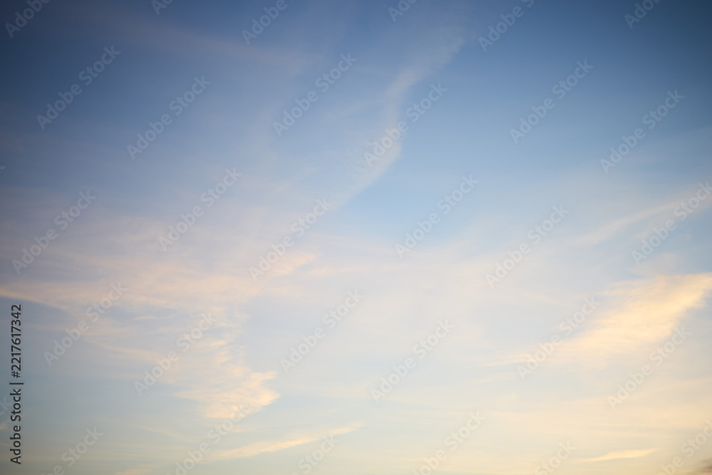 Fototapeta premium Pastel Evening Sky with Soft Clouds and Contrails, Natural Background with Copy Space