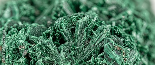 Green fibrous malachite crystal structure. Close up of natural copper carbonate mineral specimen background